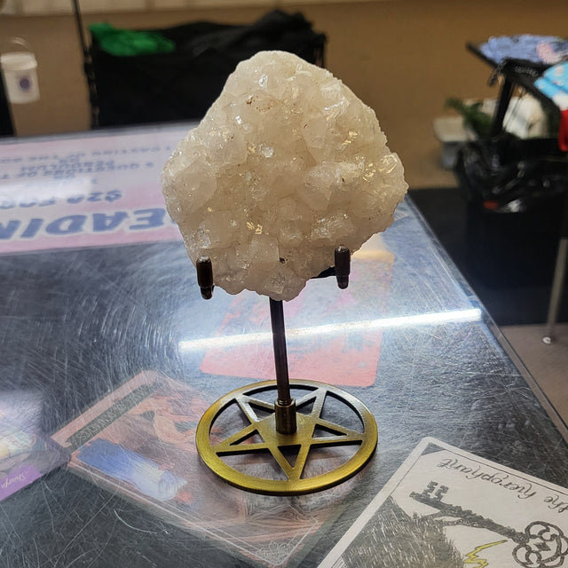 Crystal on a stand with a card in the background on a reflective surface