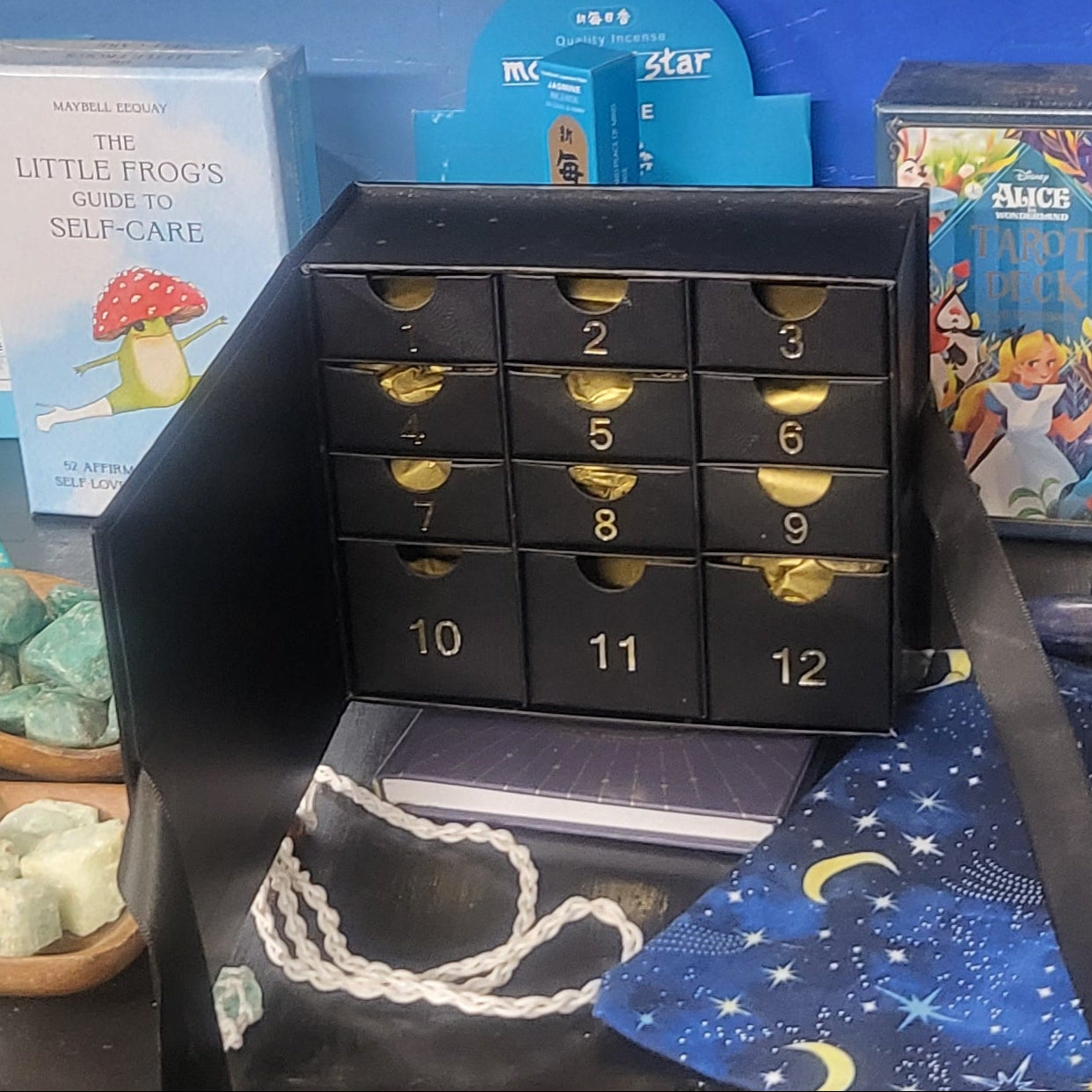 Close-up of a display with various items including a black box with gold accents and colorful cards.