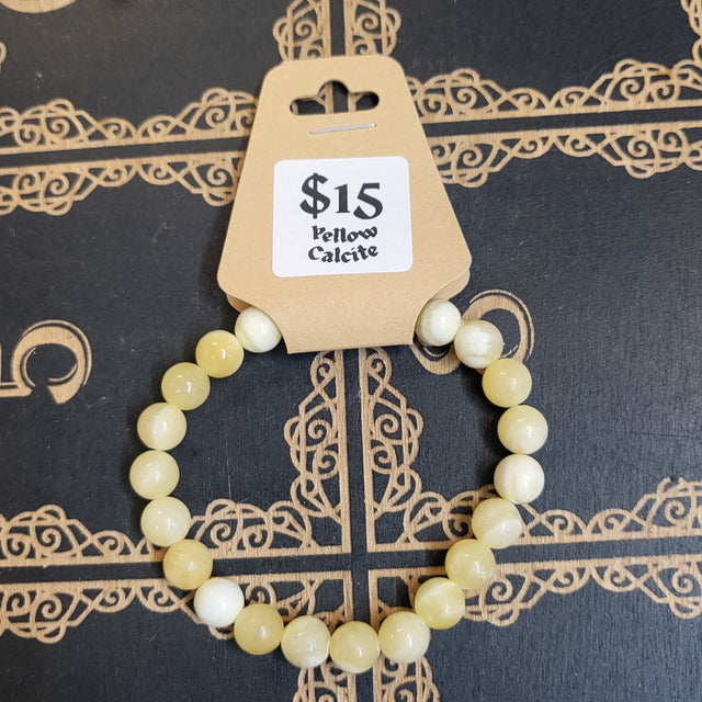 Beaded bracelet on a decorative stand with a price tag against a dark background