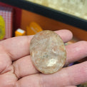 Hand holding a large oval stone with a blurred background