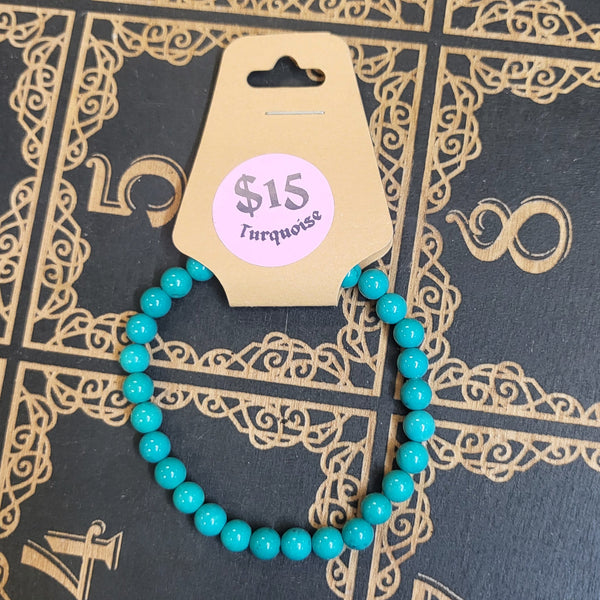Turquoise beaded bracelet with a price tag on a decorative black and gold book