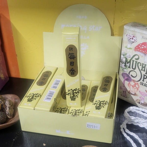Assorted items including a box, containers, and a bowl of stones on a textured surface.