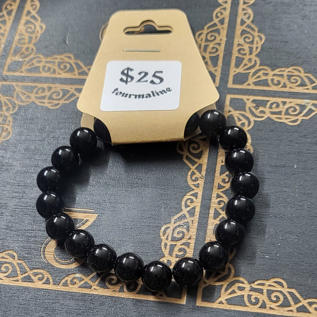 Black beaded bracelet on a witch-themed card with a price tag.